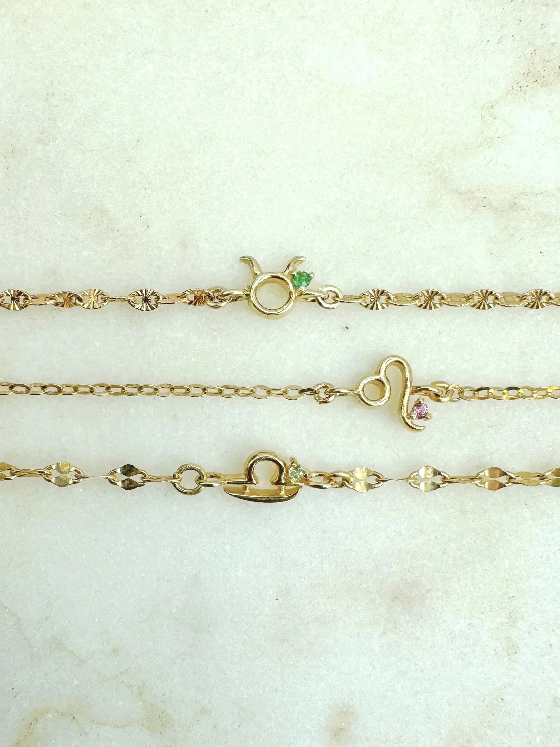 Libra zodiac charm from The Sparkle Bar. Solid 14k gold with natural peridot birthstone. Shop permanent jewelry online from Edmonton.