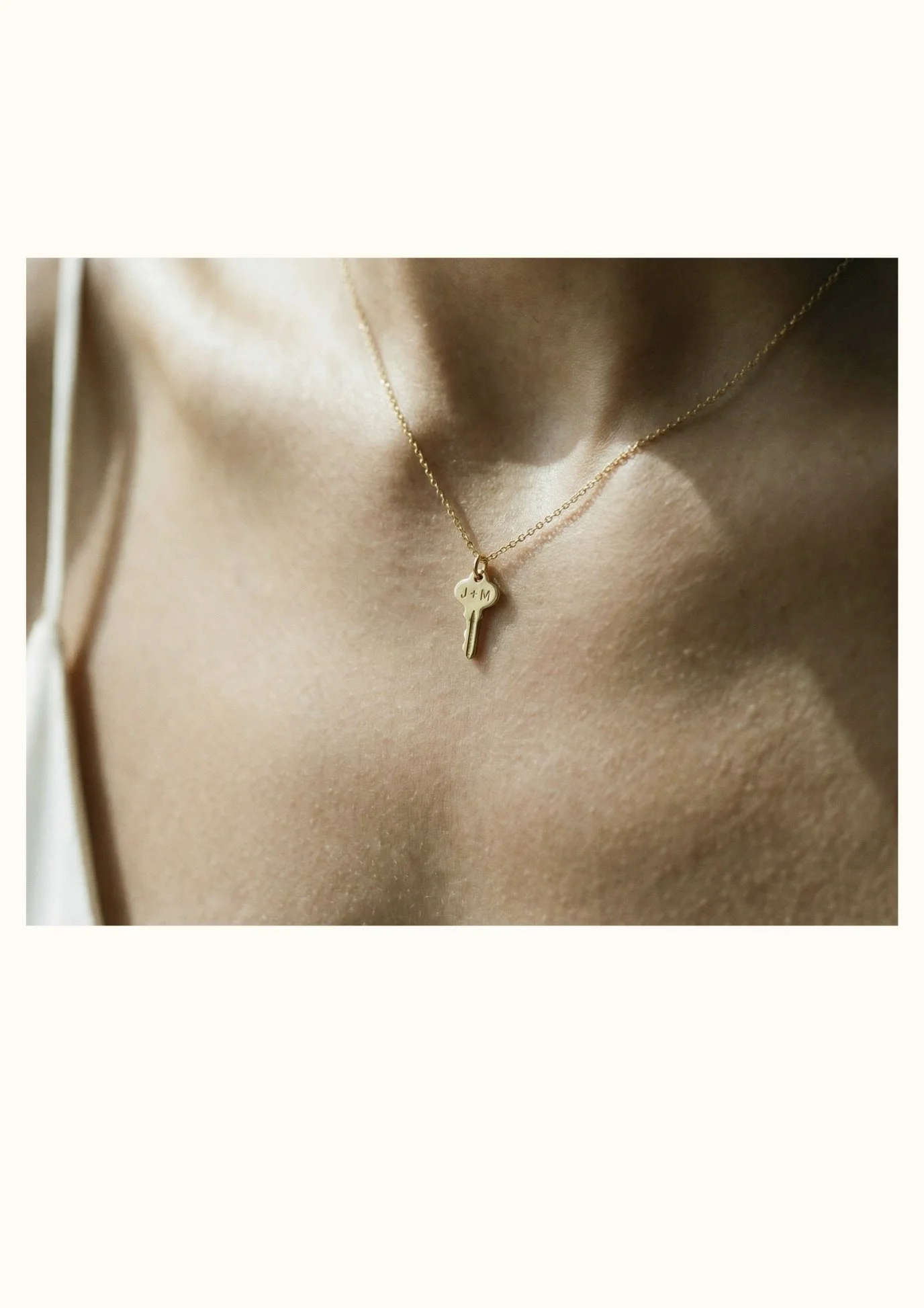 14k gold engravable key charm necklace worn, personalized with initials on delicate chain