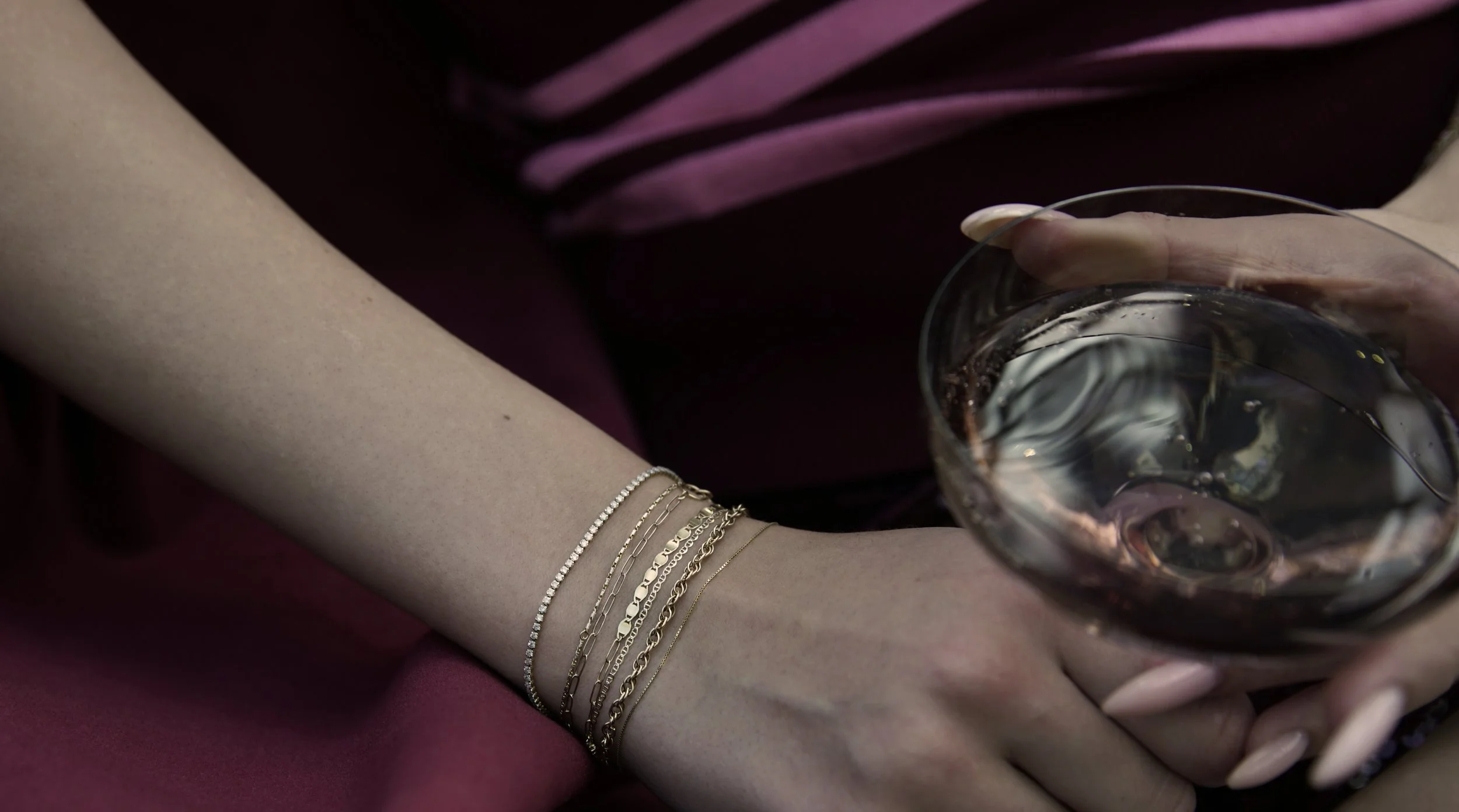 A stack of solid 14k permanent bracelets from The Sparkle Bar YEG featuring a slim diamond tennis bracelet.