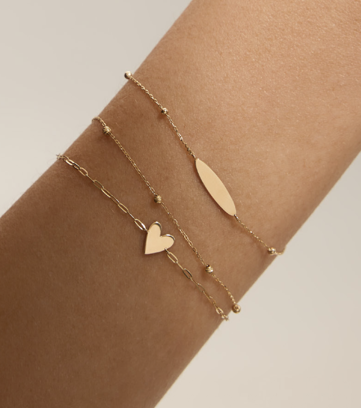 14k gold tiny signet bar bracelet layered on wrist The Sparkle Bar Edmonton