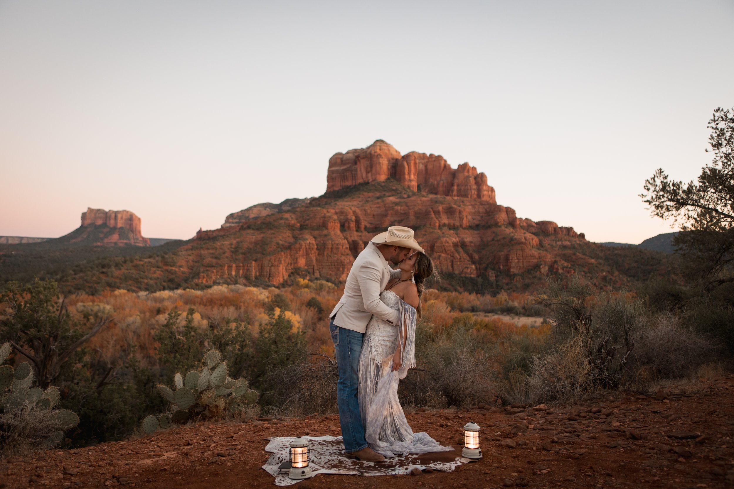 Elopement couple kissing at their ceremony at sunset in Sedona with beautiful red rock