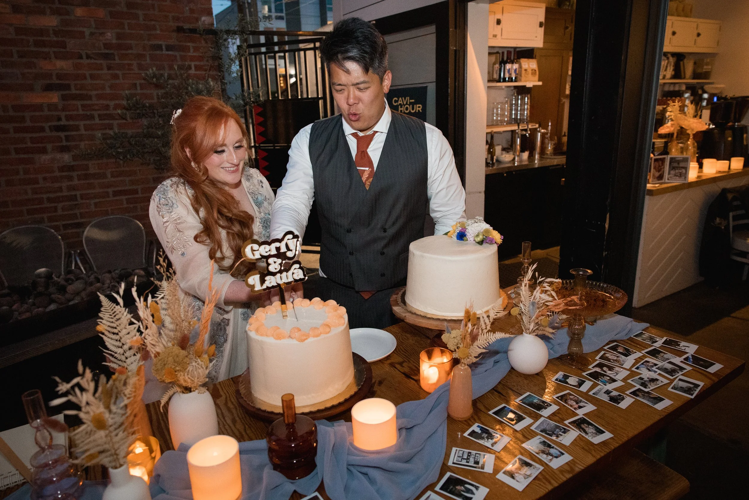 Micro wedding couple cutting cake at Brimmer & Healtap, bride is smiling and groom is making a funny face. Candle light with beautiful decor