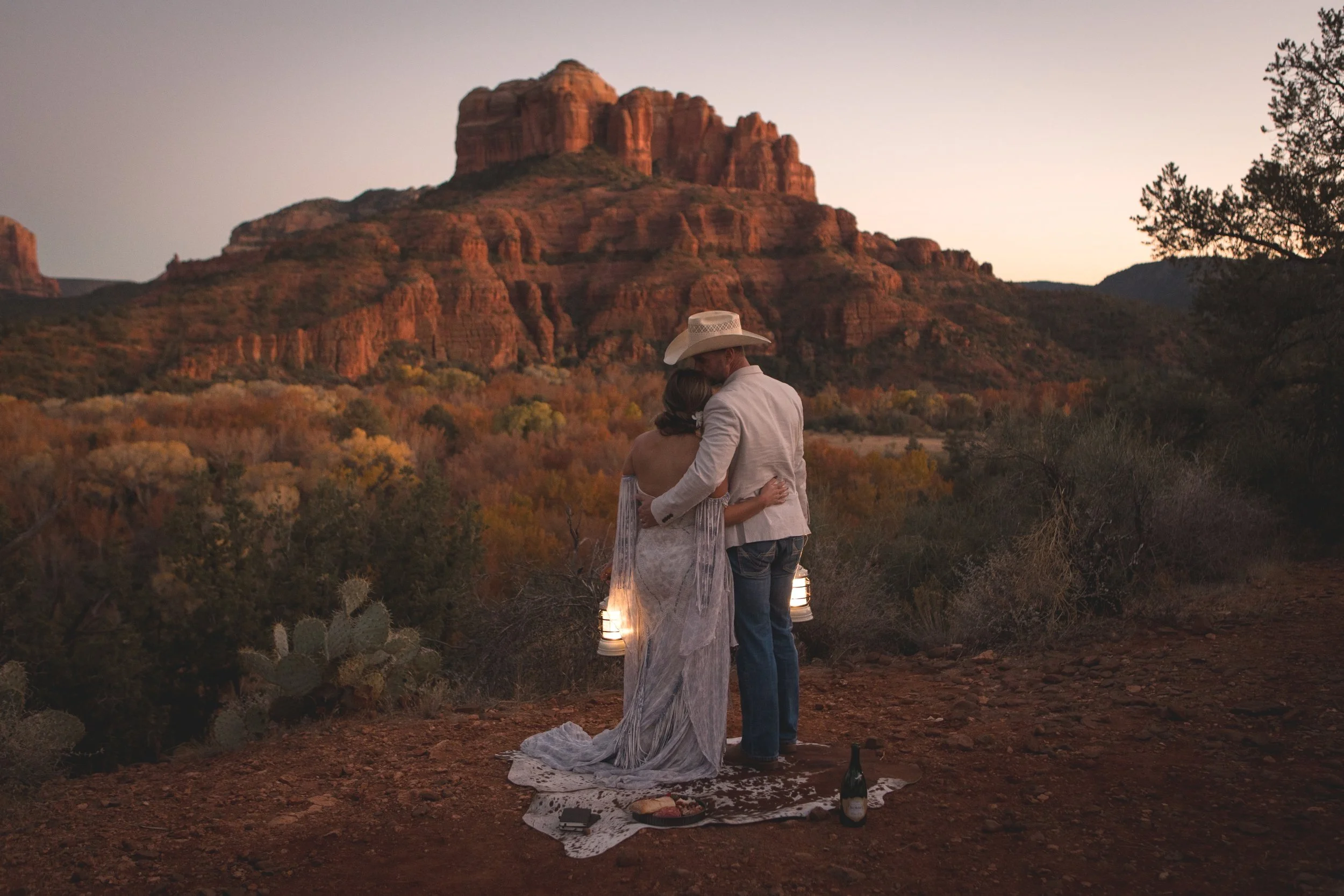 Elopement in Sedona holding each other watching the sunset with lanterns