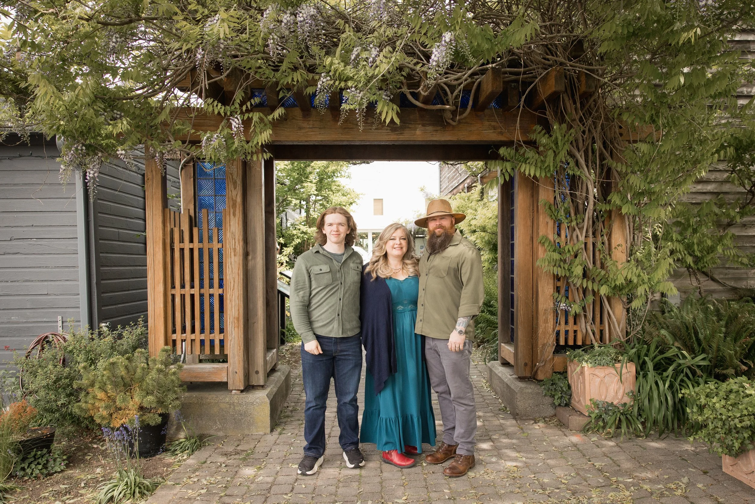 La Conner whidbey Island family standing together under a big arch of wisteria for family photos