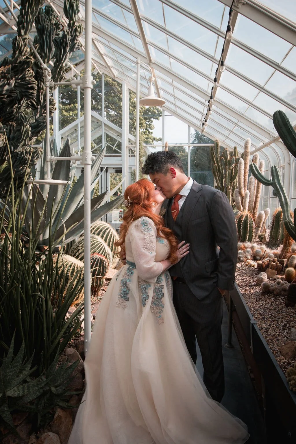Bride and Groom kissing in Volunteer Parks desert greenhouse