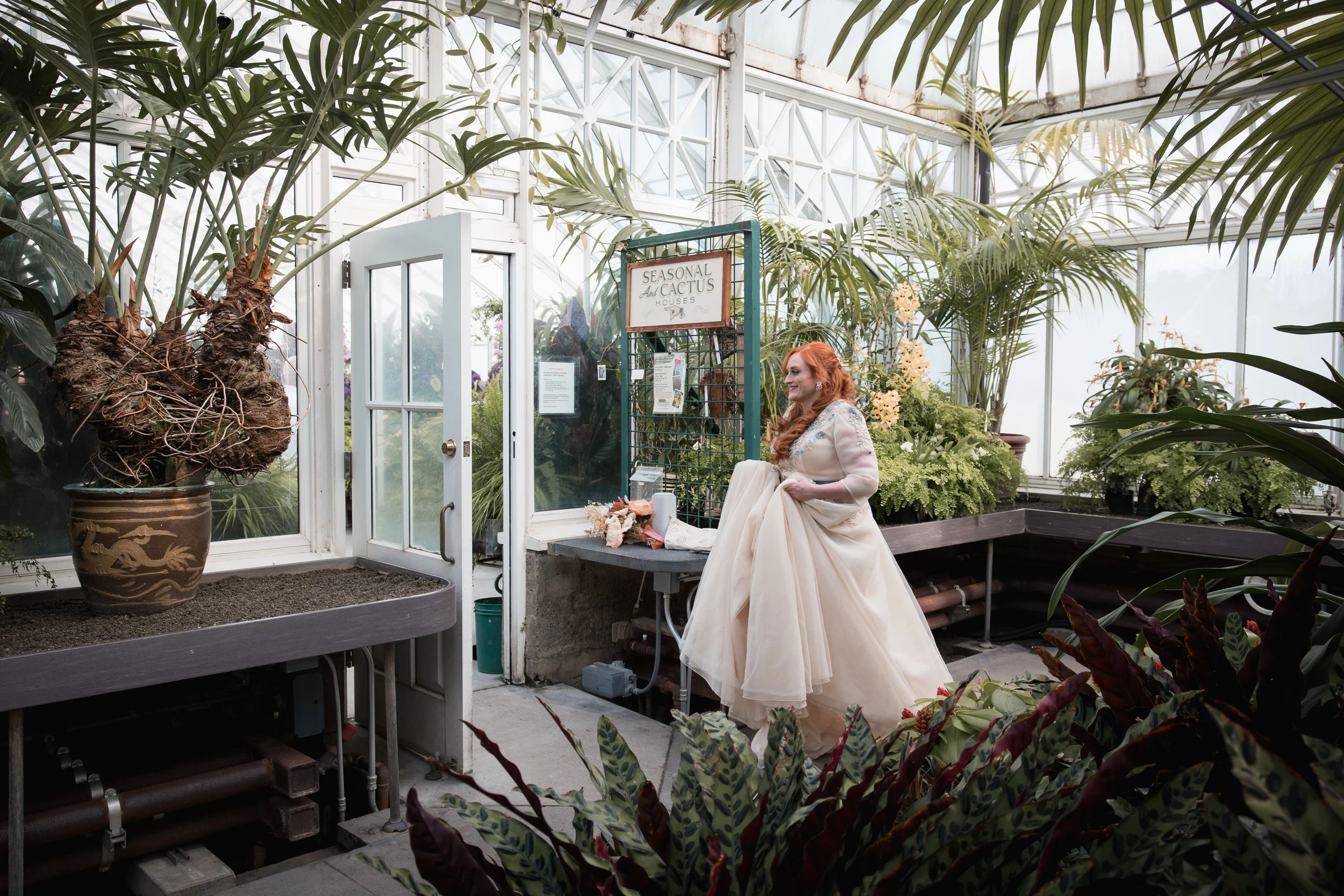 Red haired bride with dreamy dress walking through Volunteer Conservatory in Seattle