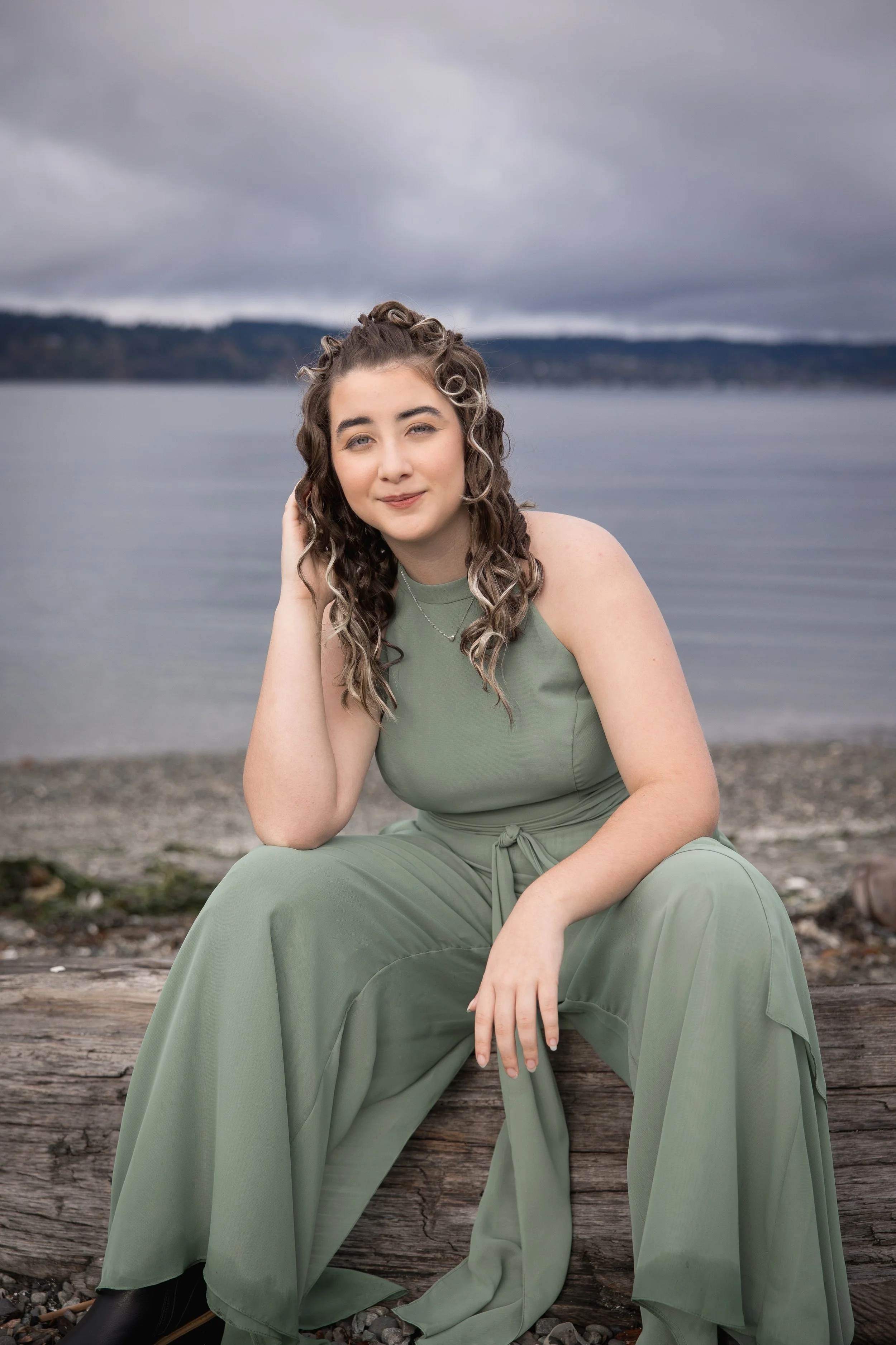 Mukilteo High School Senior girl portrait at the beach sitting on a log in power pose