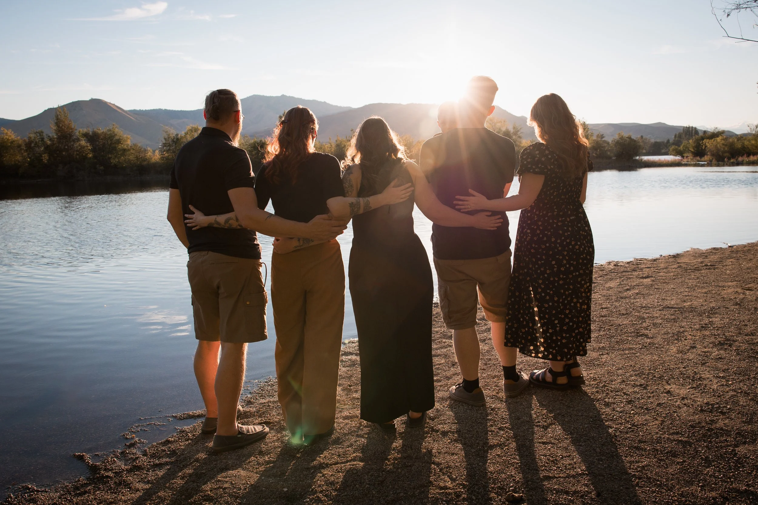 wenatchee wa family looking at the sunset holding waists for family photos