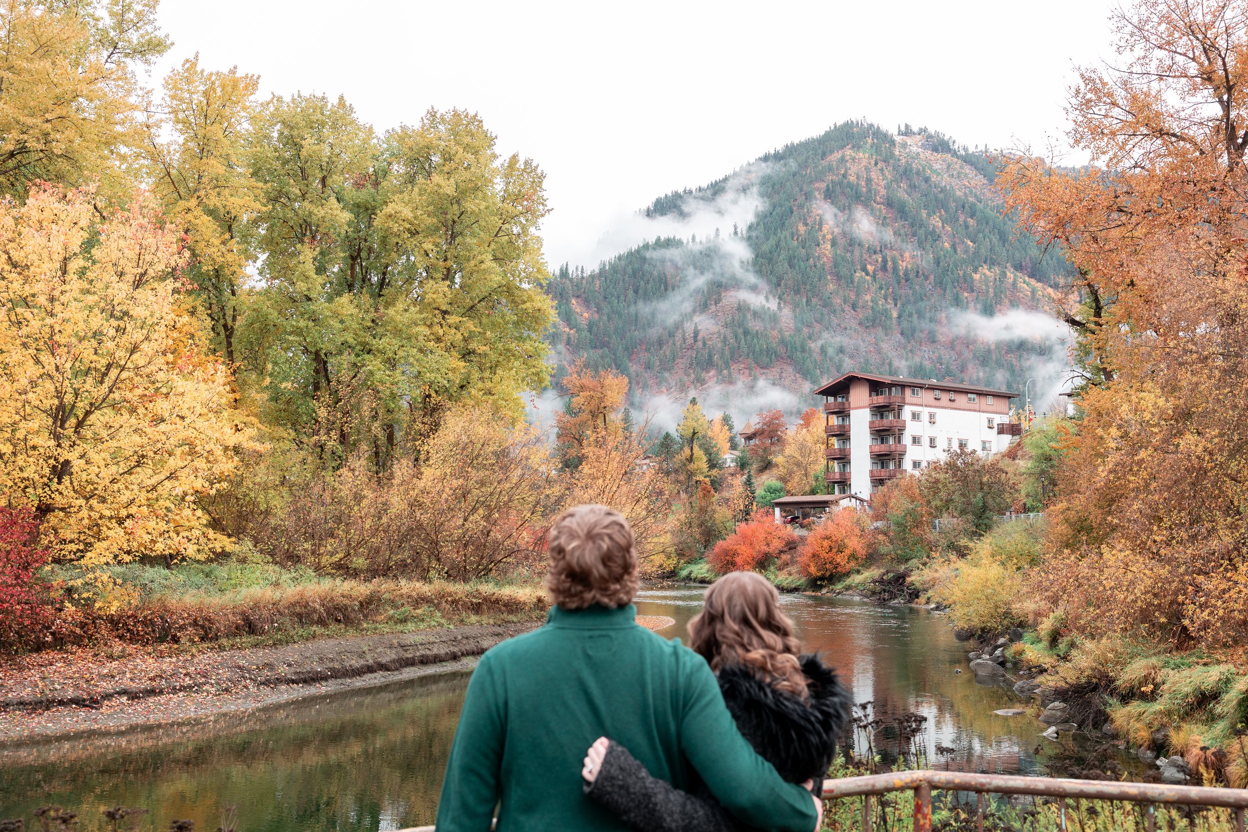 Couple embracing and looking towards the fall colors and mountains in Leavenworth WA