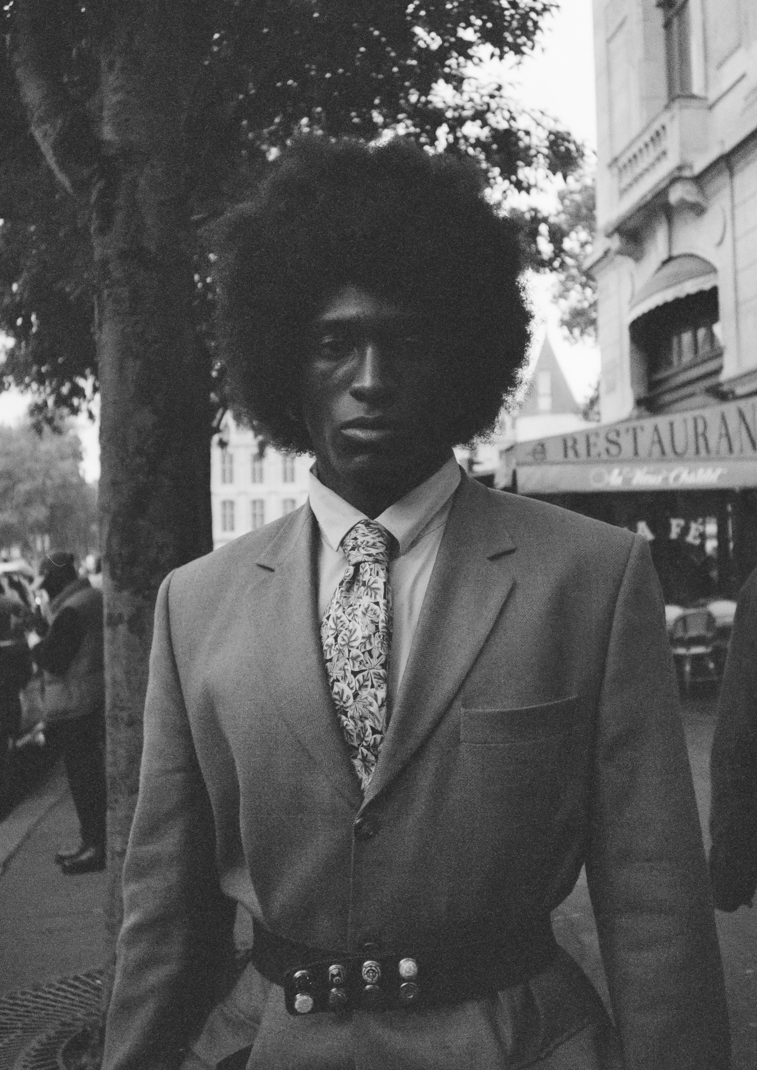 Portrait shot on black and white film. Model is named Joe. Images was shot on a Pentax 17. He has afro hair, and is wearing a suit.
