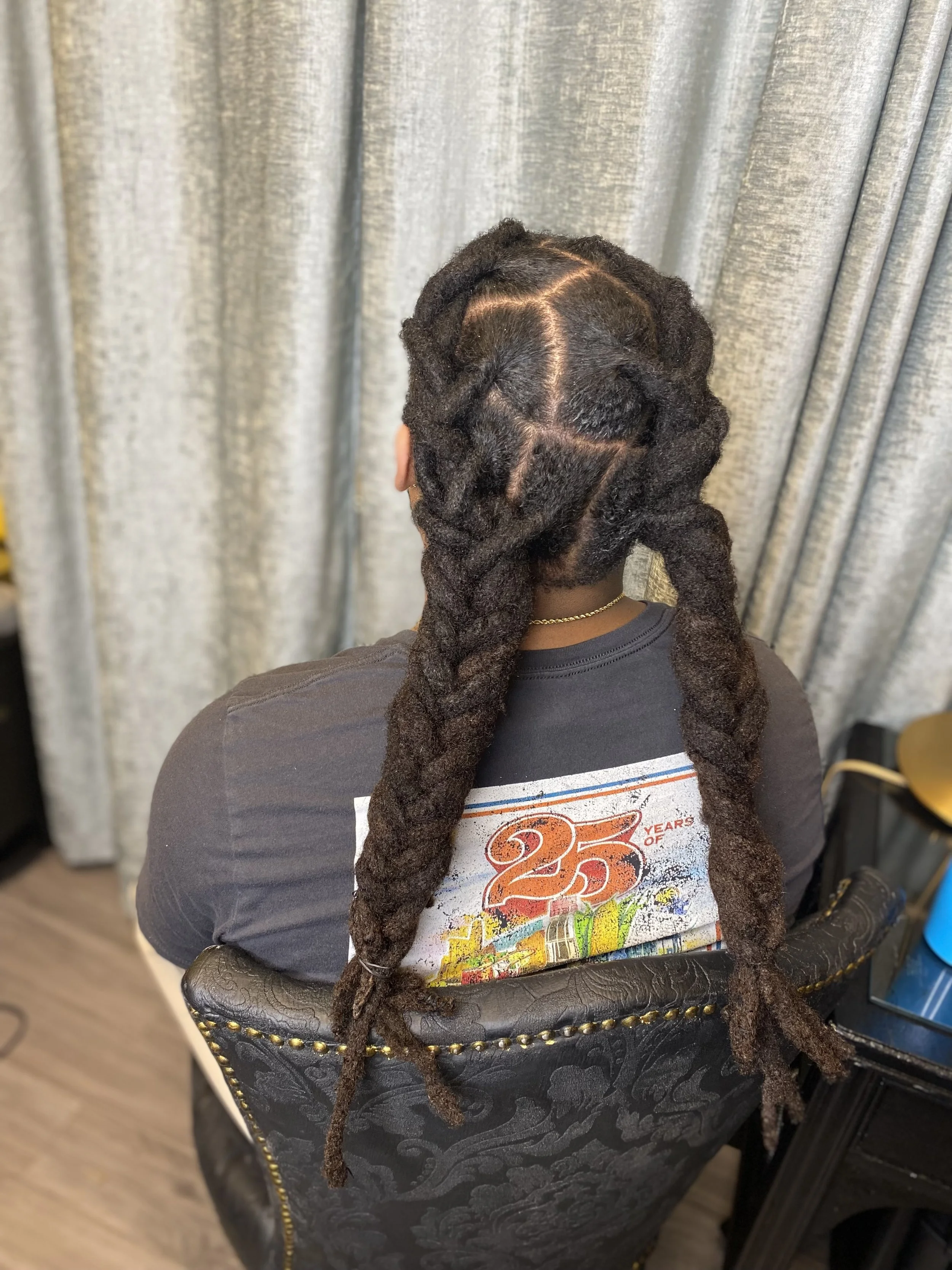 Back view of woman with styled dreadlocks sitting in a chair.