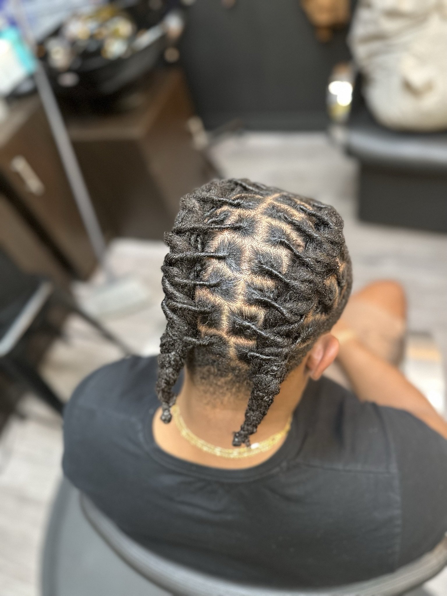Top view of a person with freshly styled dreadlocks, showing the neat parting and twists on their scalp.