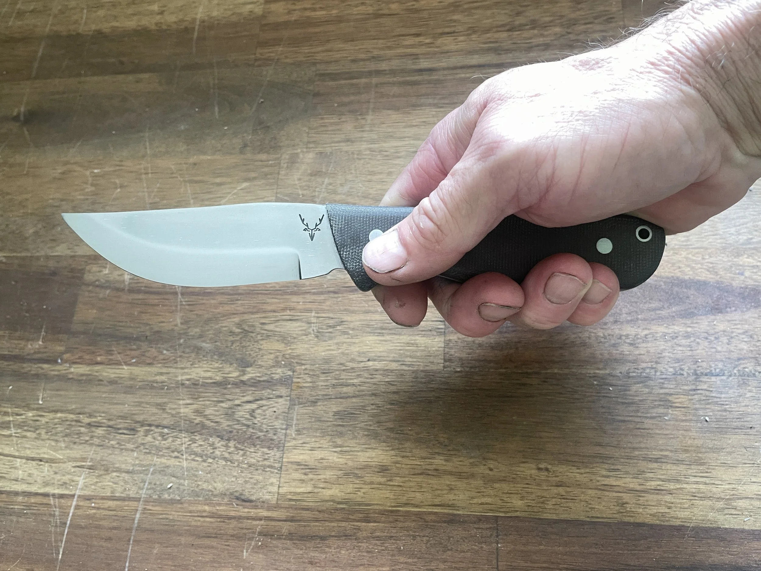 Ultimate Hunter Knife with Olive Micarta Handle in the hand