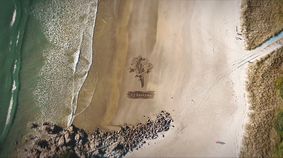 Wide aerial photo of Ed Sheeran sand art commission Mount Maunganui Beach New Zealand