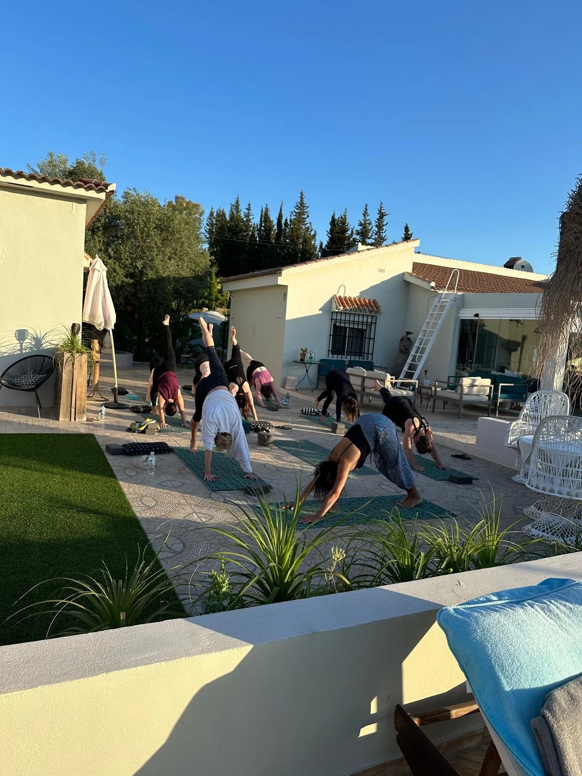 Group of people practicing outdoor yoga on patio