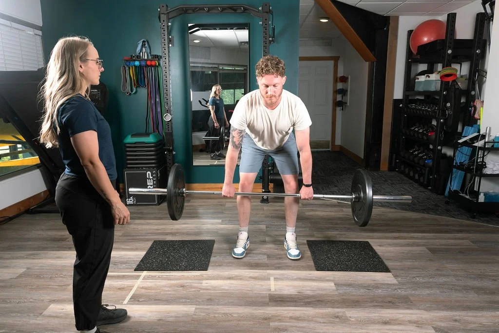 Physiotherapist at Ridgeline Physio giving education on deadlifts during rehabilitation of a knee injury in Fernie, BC