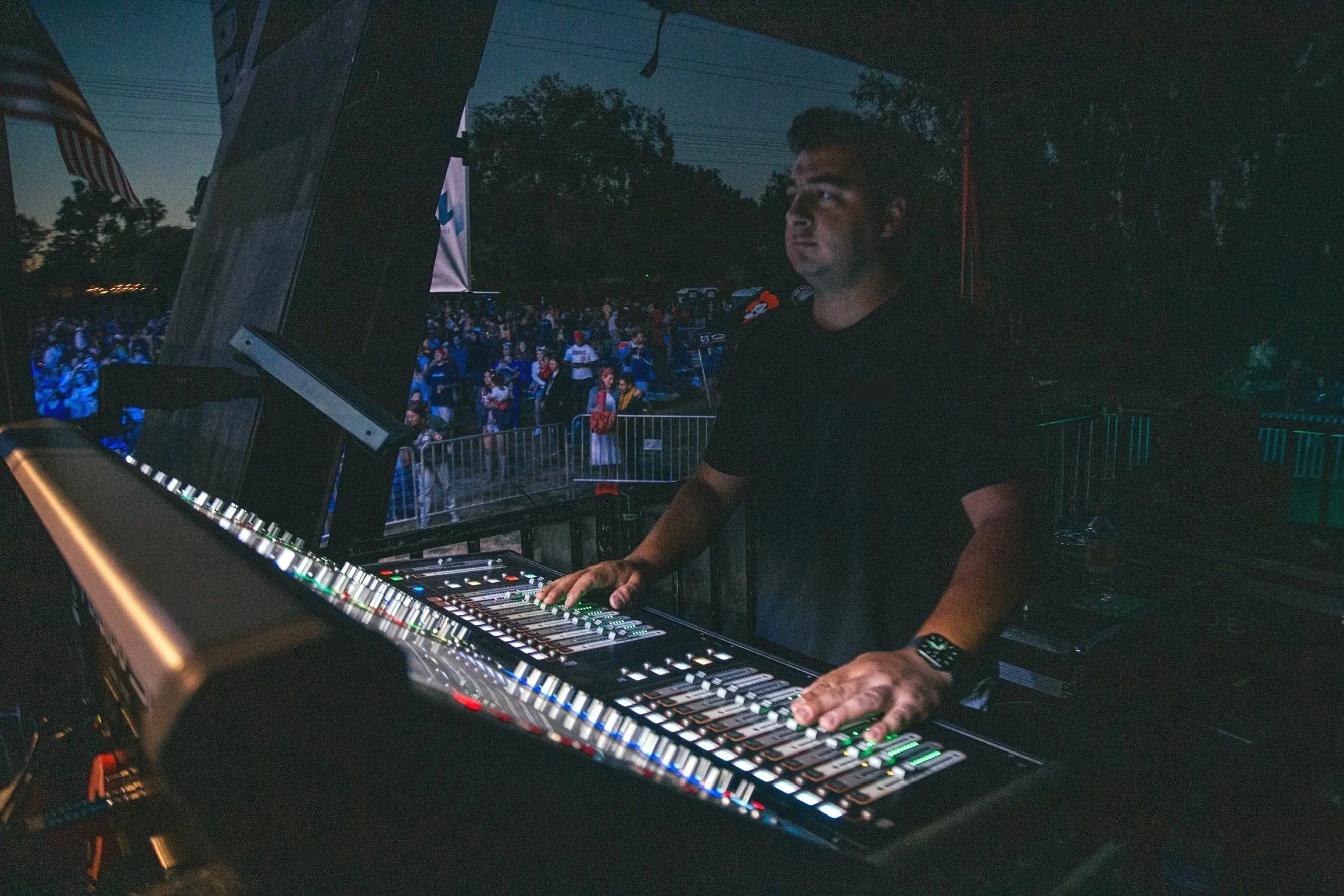 Professional live event audio setup with mixing console and stage lighting by Point Loma Sound