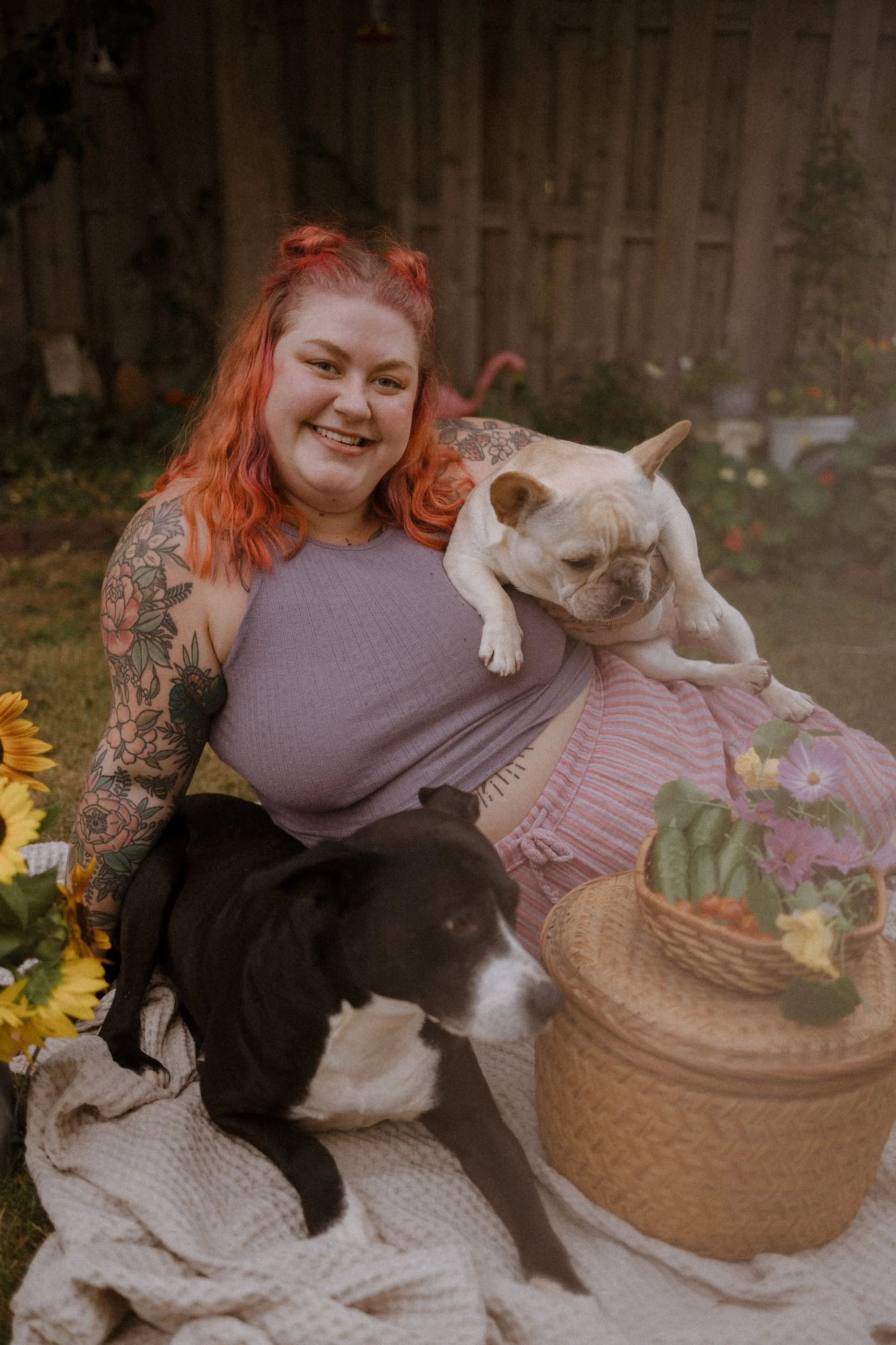 Holly poses in her garden with her dogs Lemon and Shugie and a basket full of goodies she freshly harvested.