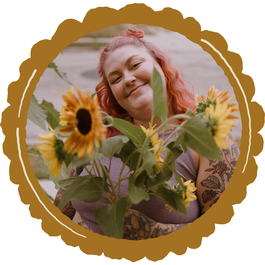 Holly smiles holding an armful of sunflowers she grew in her garden.
