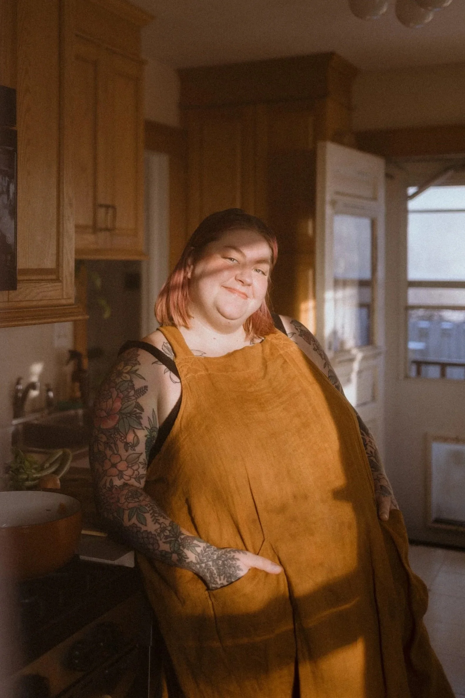Holly poses in her kitchen as the sunlight casts shadows on her face.