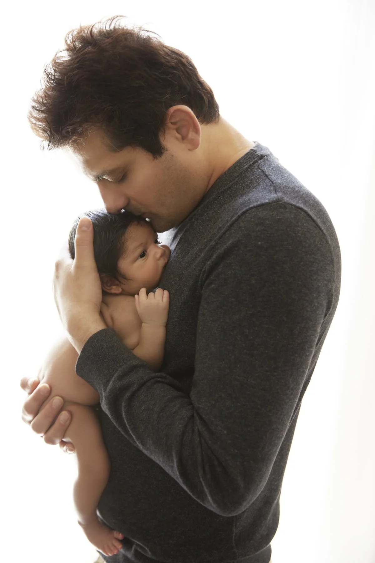 tender moments of dad kissing his newborn baby girl.jpg