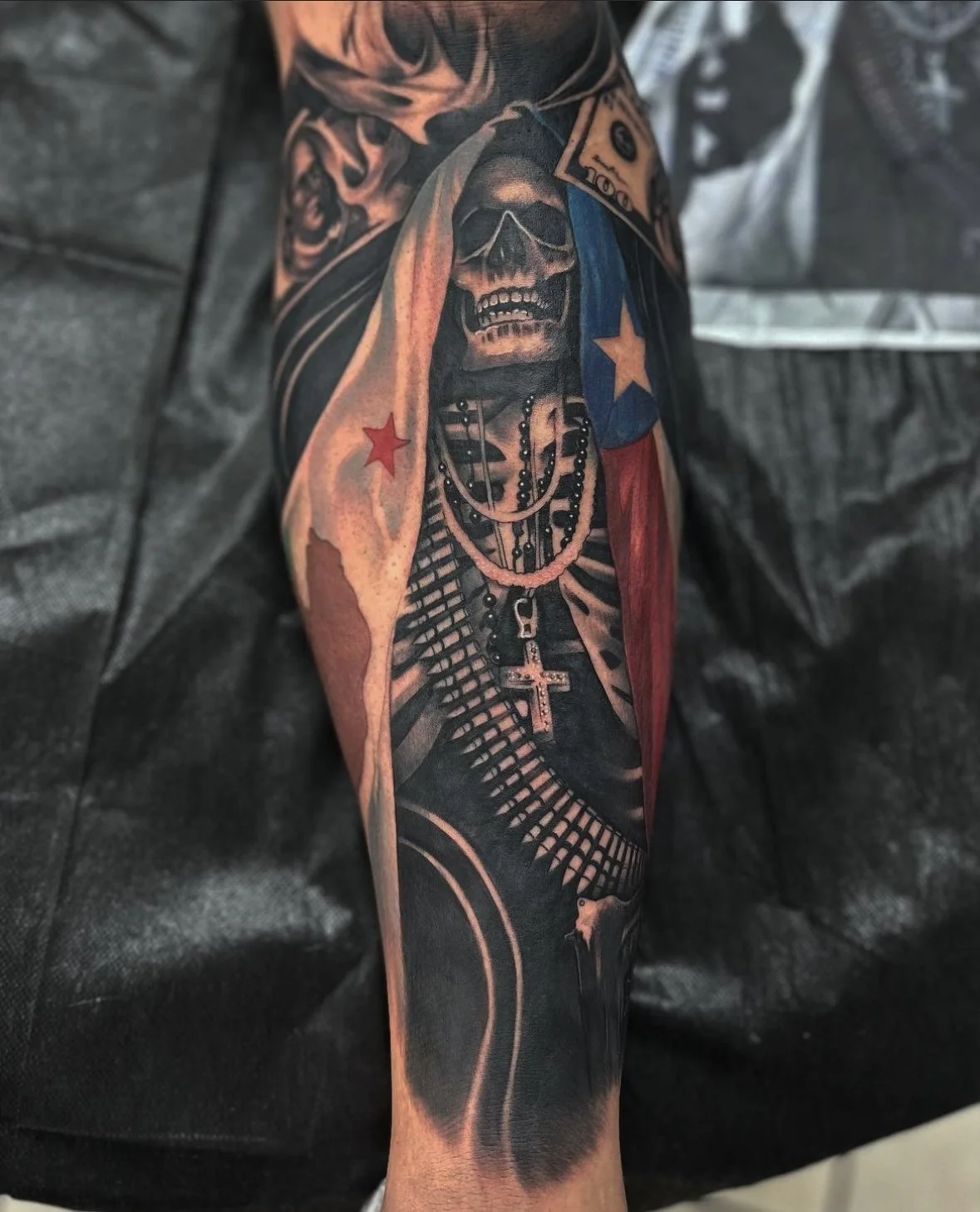 Colorful tattoo of a skull wearing sunglasses, with Puerto Rican flag elements, necklaces, and various decorative details on a person's arm.