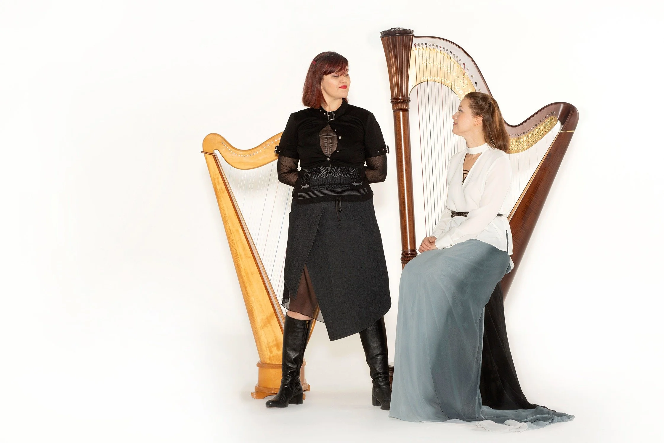 Harp and vocal duo Harp 2 Harp pose with their instruments against a white background.