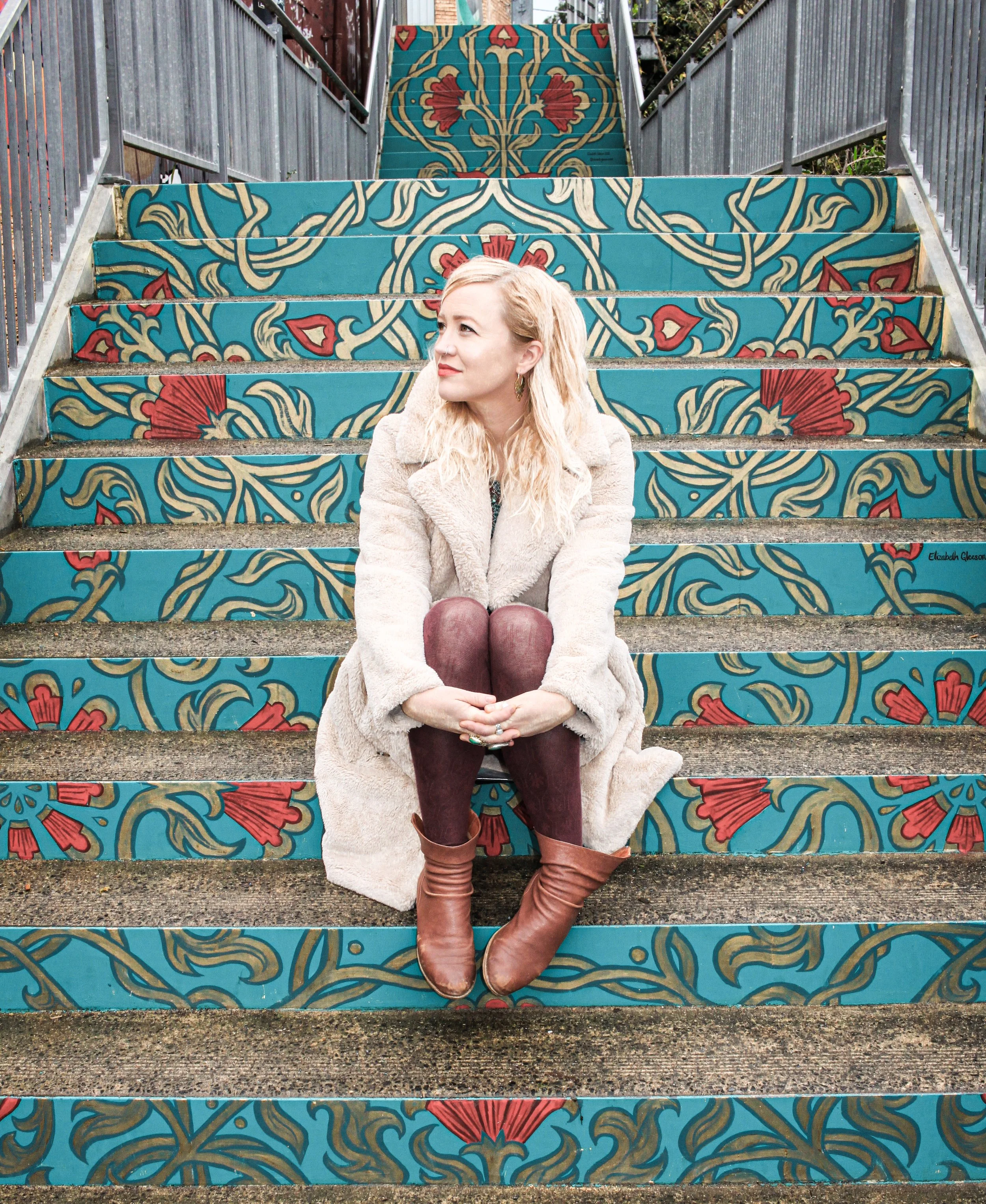 The artist sitting on the steps she painted in Belgrave in 2023.