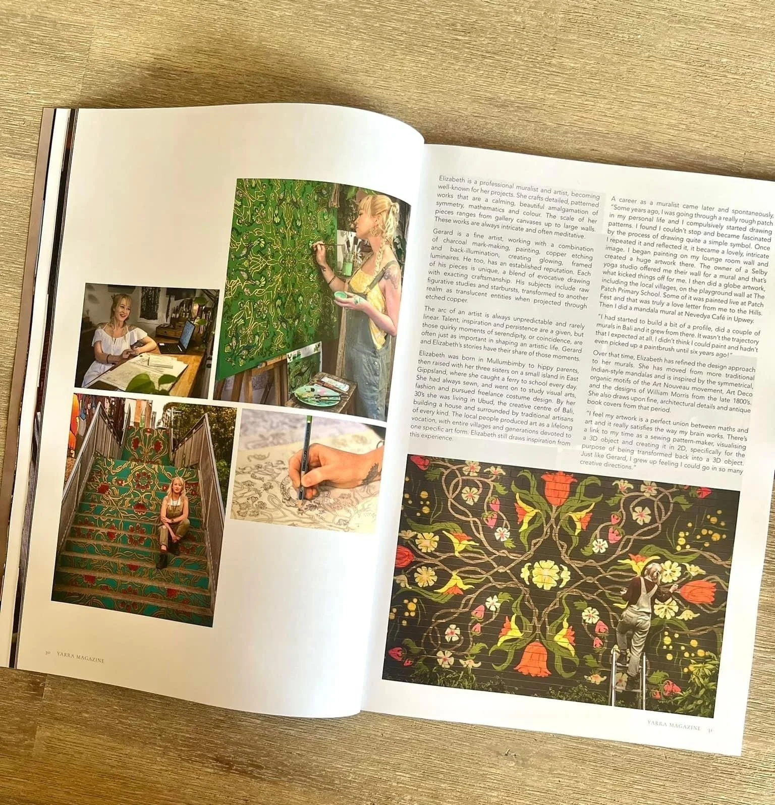 Open magazine showing artist portrays, is painting a detailed green floral wall. Photos include a woman painting, sitting on a staircase with colorful carpet, writing on a patterned fabric, and working at a computer at her desk.