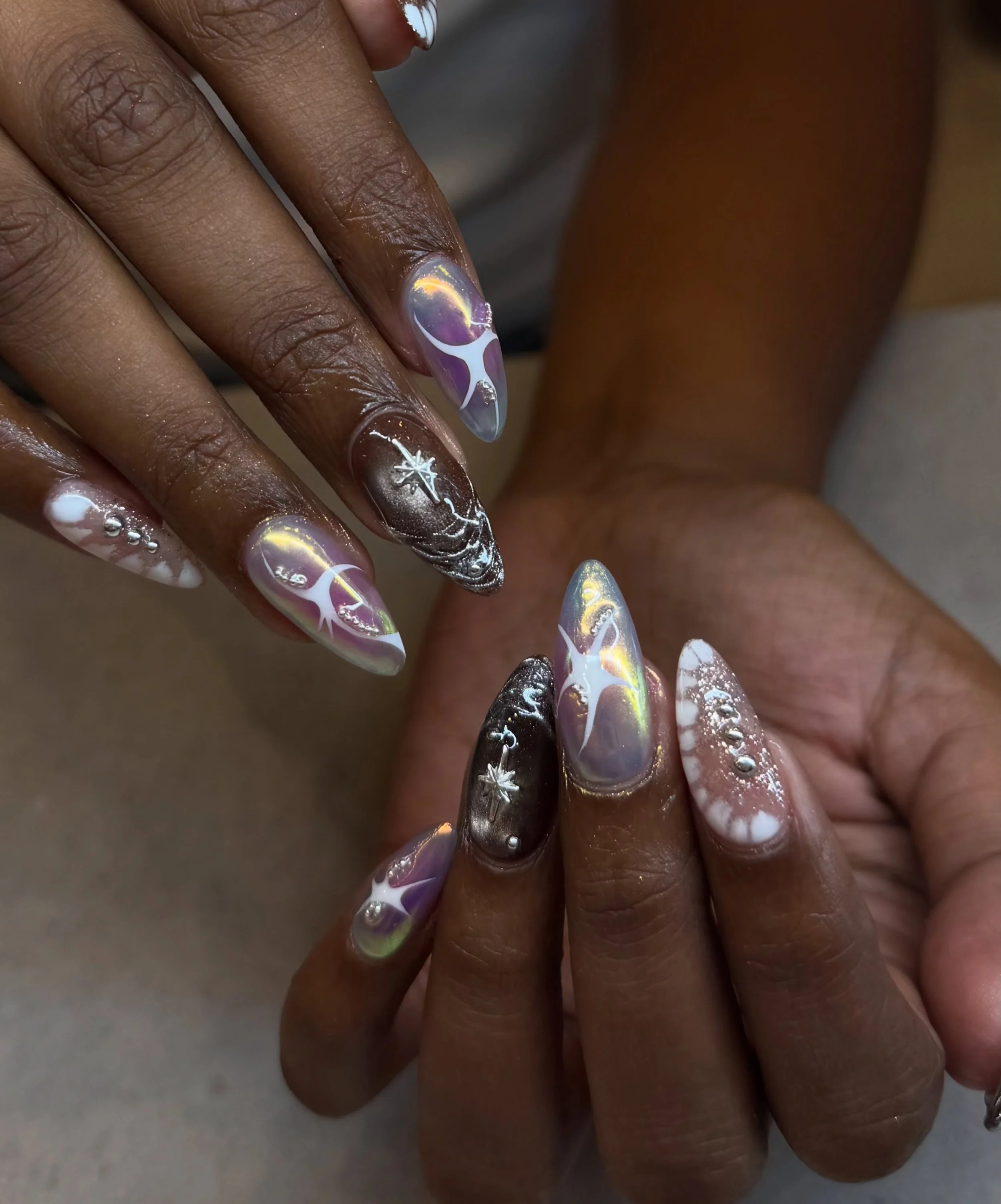 Is there anything our master artist can&rsquo;t do? Just wow! Look at these set of nails. 🤩

Nails by Master Artist, Amy. ❤️&zwj;🔥

#y2knails #cybernails #chromenails #auranails #cateyenails cat eye nails, aura nails, chrome nails, cyber nails, Y2K