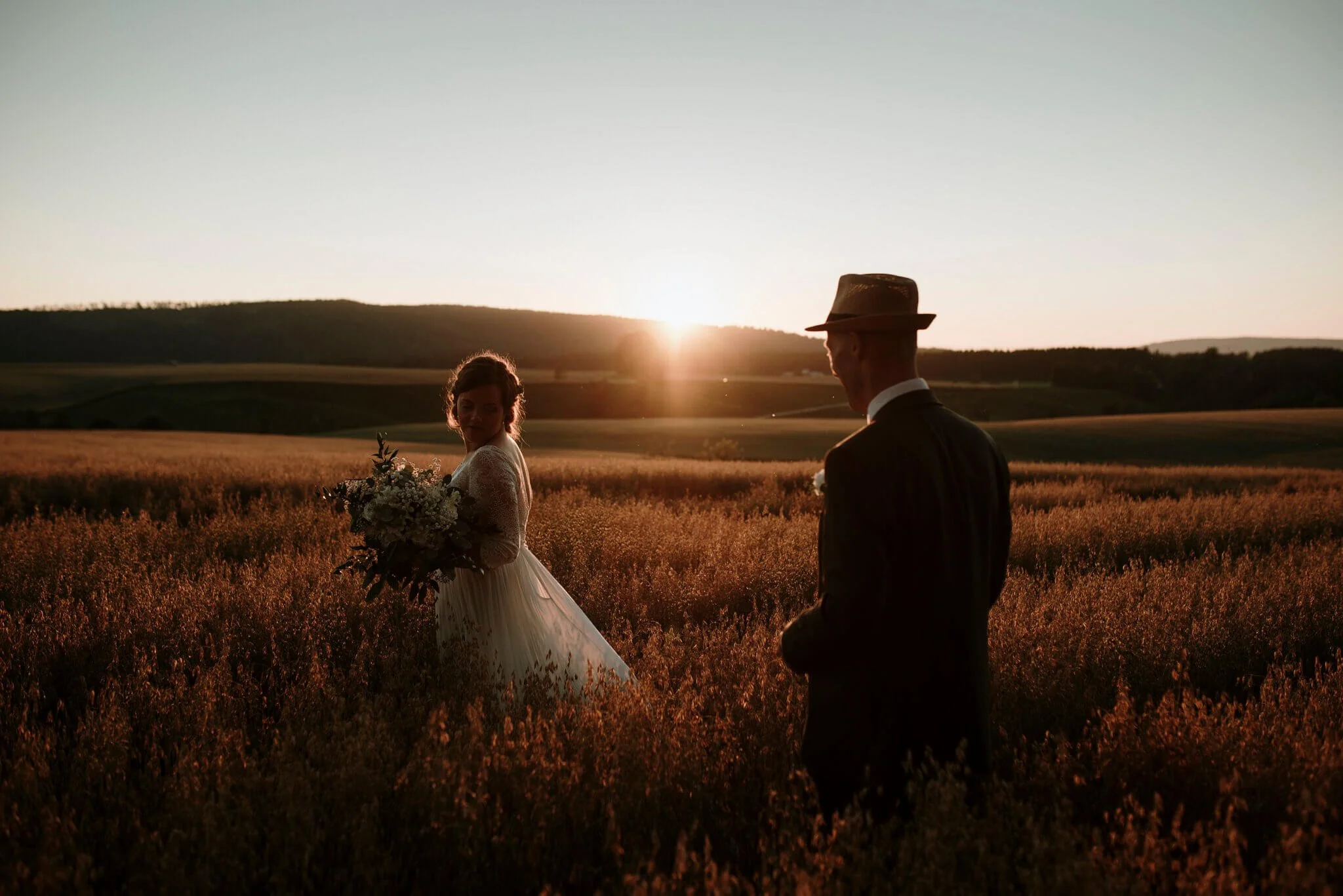 brudepar i åker i solnedgangen