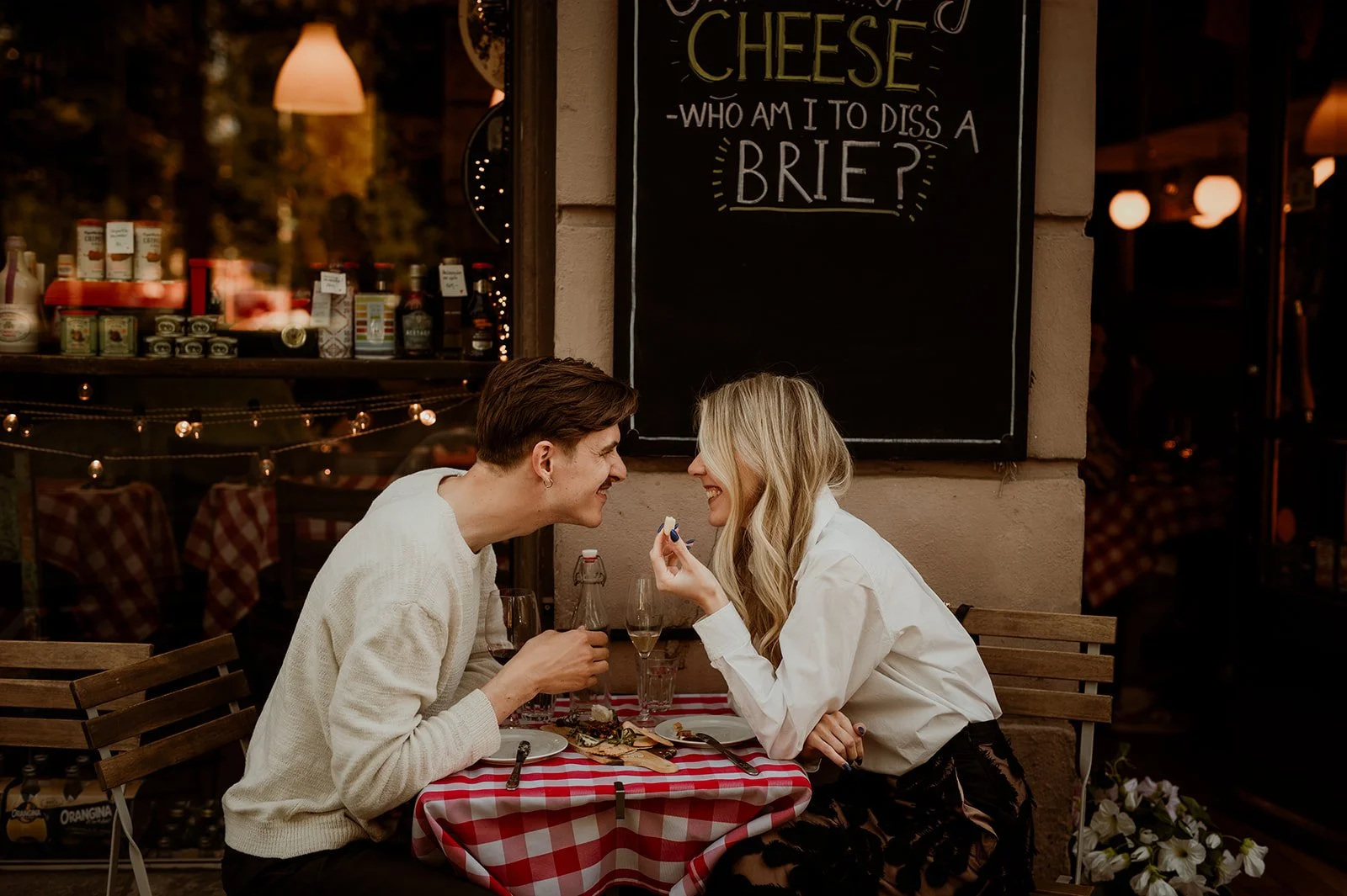 To mennesker som sitter på en restaurant og spiser ost og kjeks