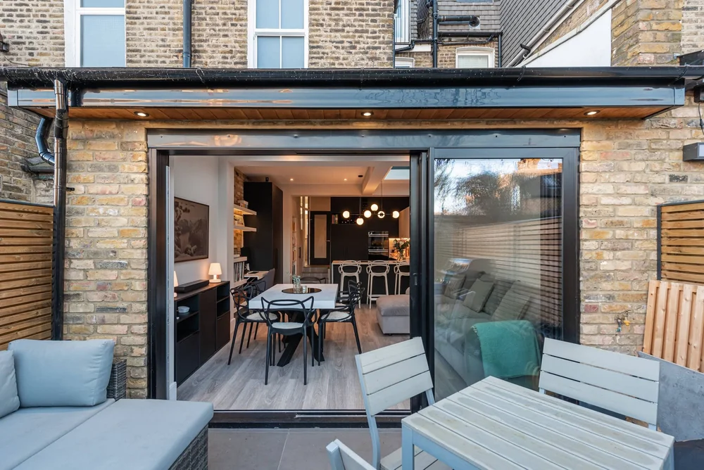 Architect's drawings for a kitchen extension laid out on a table.
