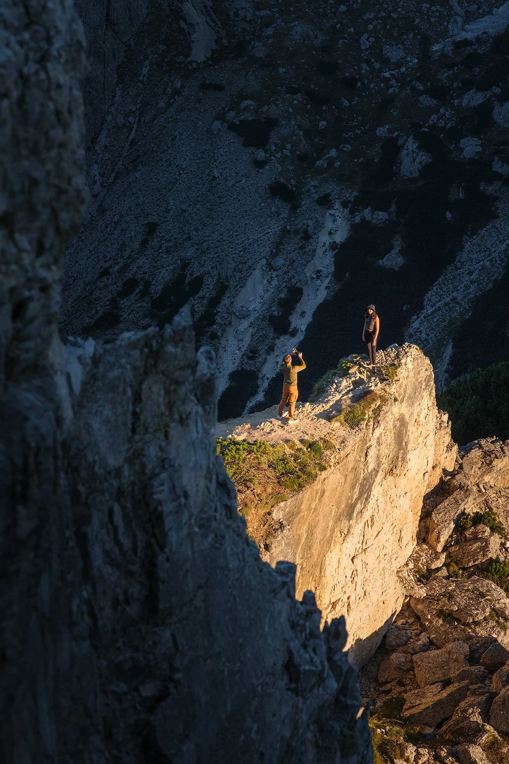 A narrow patch of sunlight illuminating a rock pinnacle between shaded cliffs at Cadini di Misurina.