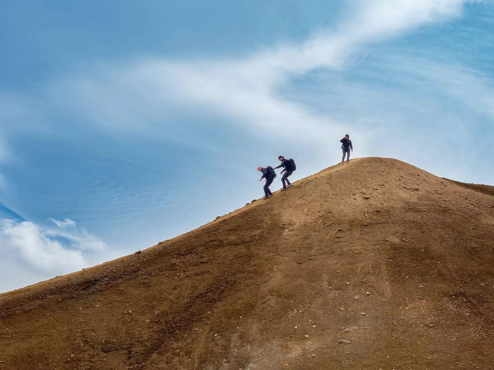 Photographers hiking down a ridge in the Landmannalaugar area