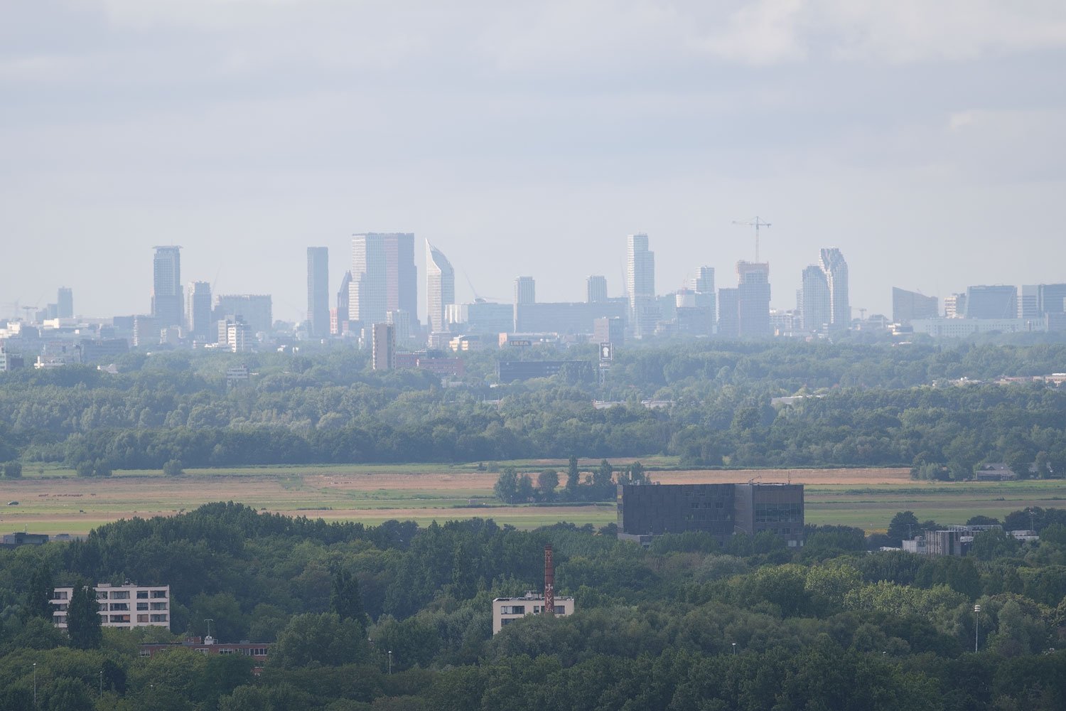 First of two consecutive 400mm photographs of a distant IKEA sign and skyline through atmospheric haze.