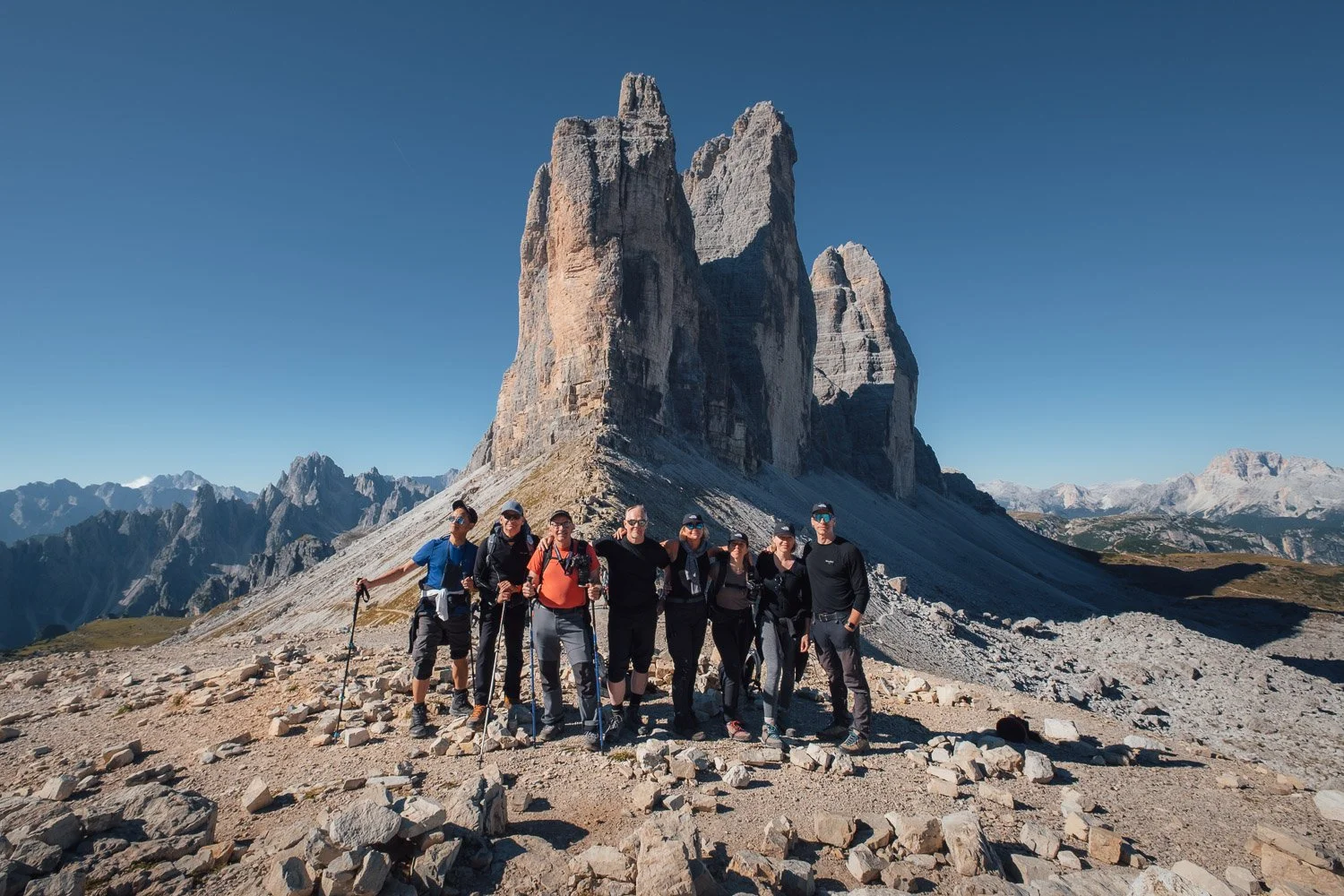 The 2026 Dolomites Immersive Photography Workshop group standing together beneath the rock towers of Cinque Torri.