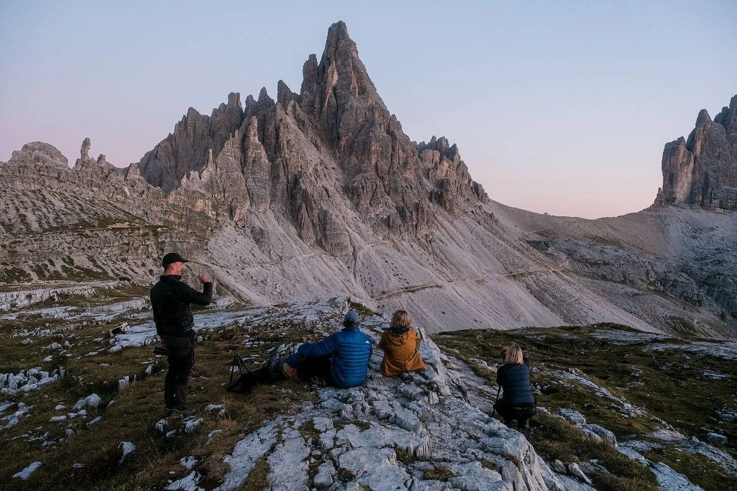 Workshop participants photographing the rocky peaks near the mountain hut as evening falls.