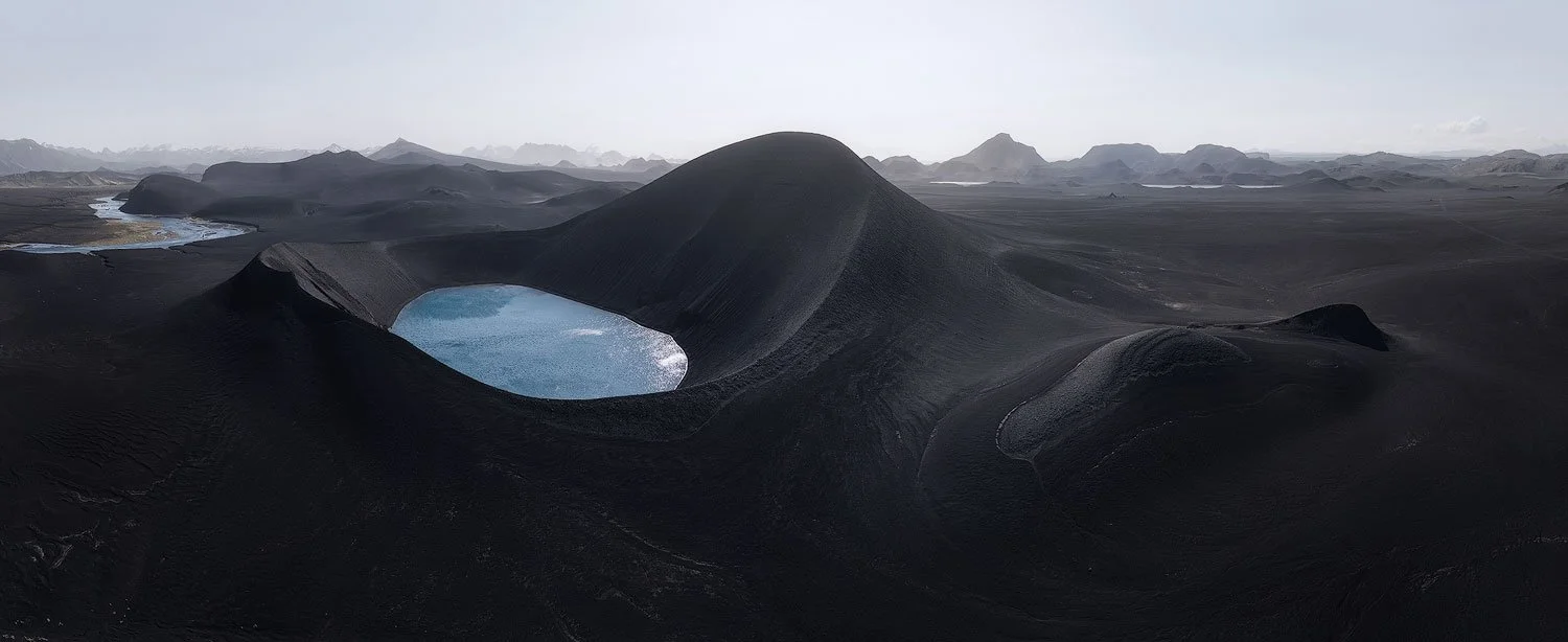 DJI Mini 4 Pro aerial panorama of black volcanic ridges and blue crater lakes in the Icelandic Highlands.