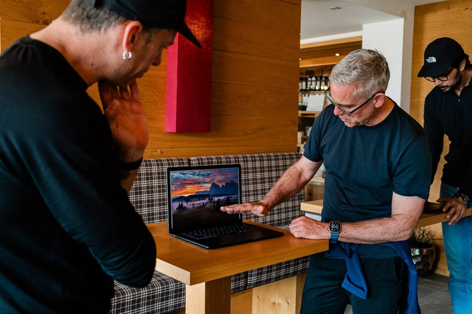 Andrea Livieri and workshop participants reviewing Fred’s edited photograph of a colorful sunrise at Alpe di Siusi.