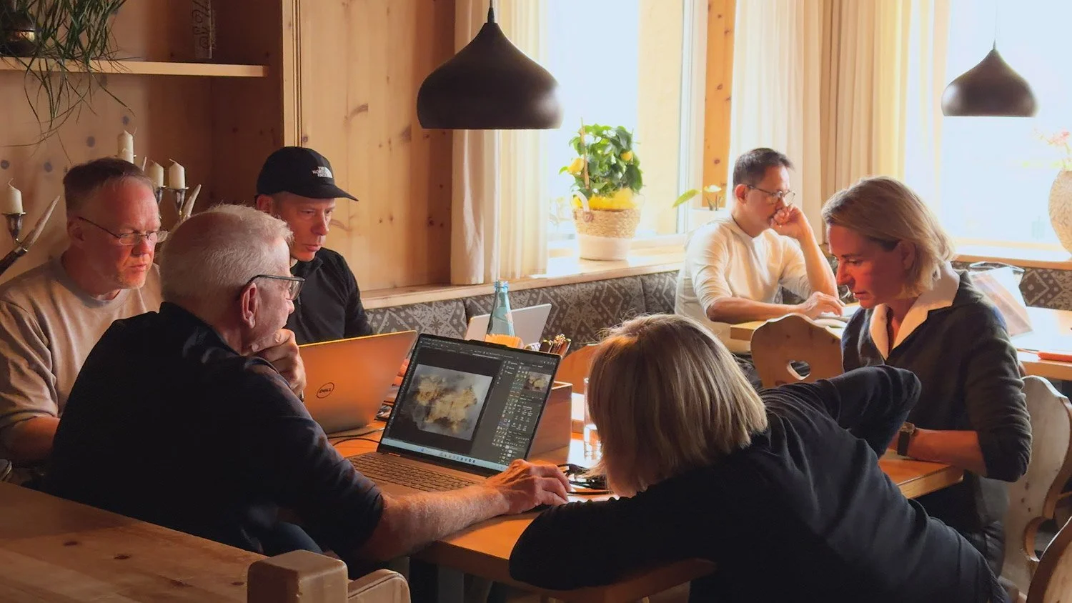 Workshop participants gathered around a laptop to review and discuss photographs from their week in the Dolomites.