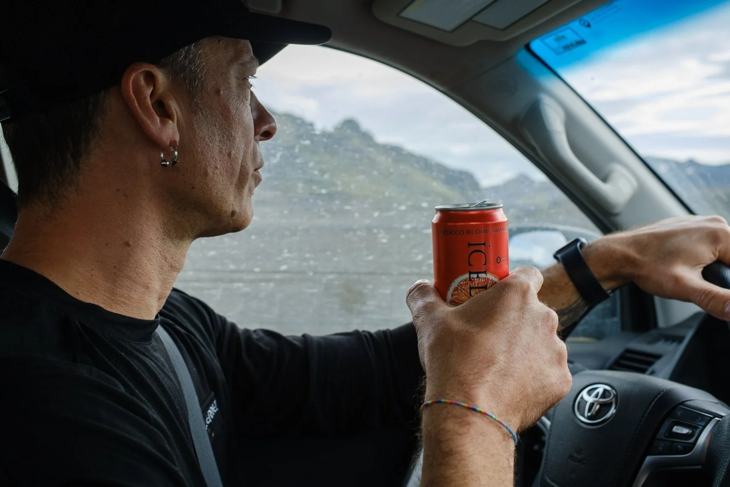 Andrea livieri portrait in the car while driving in the iceland highlands holding a can of beverage photographed by Sabrina Tosato