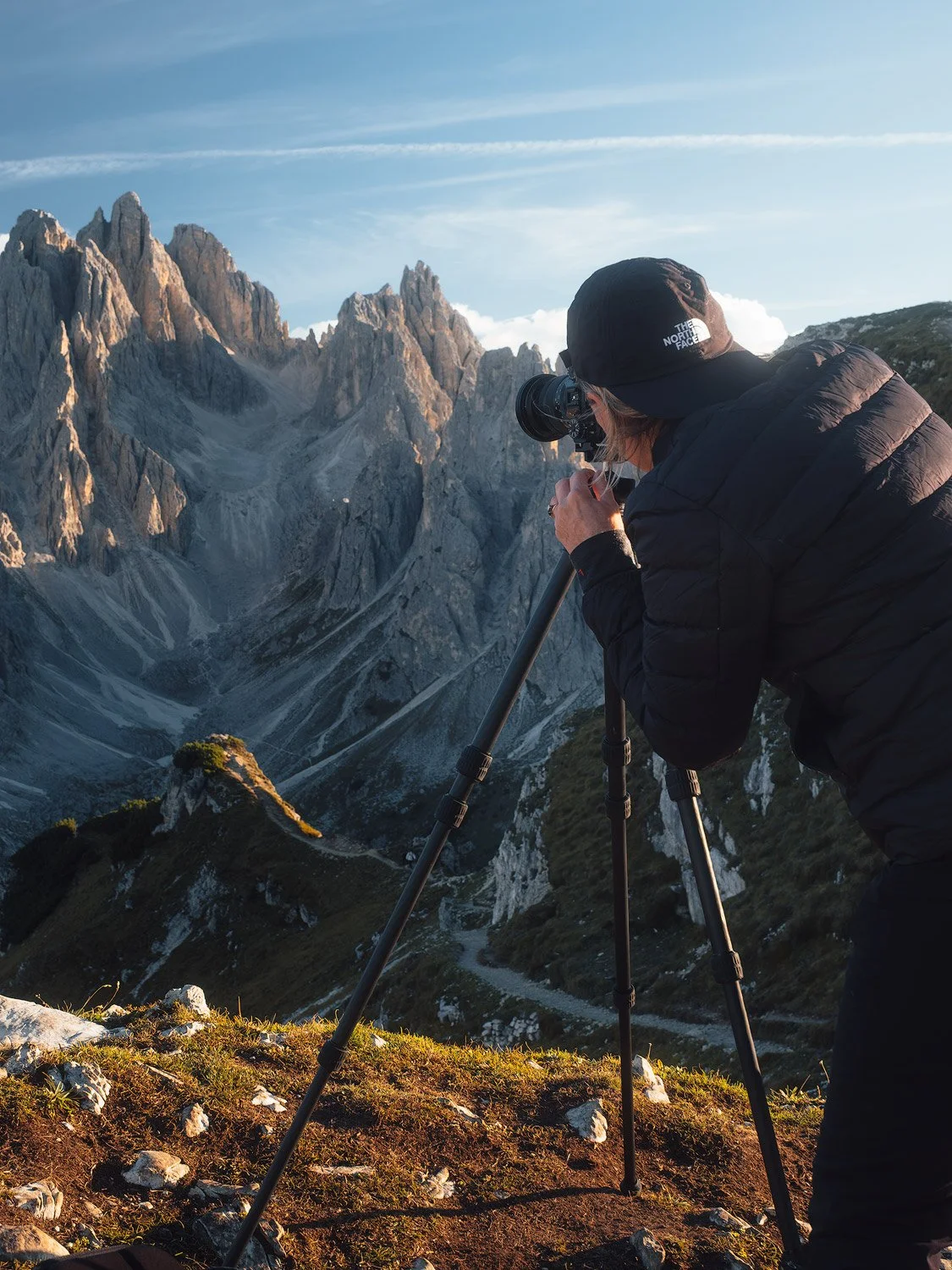 A workshop participant photographing Cadini di Misurina with a camera on a tripod.