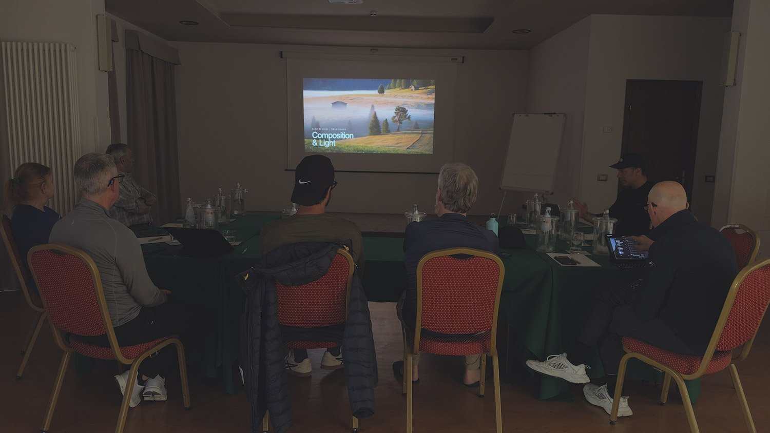 Dolomites Signature Workshop participants reviewing landscape photographs together during an indoor image discussion.