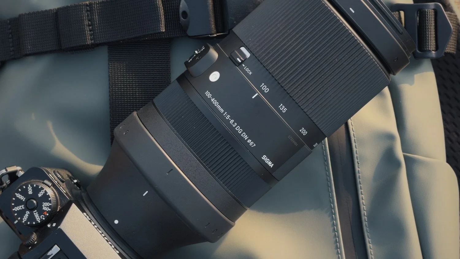 Close-up of the Sigma 100–400mm zoom barrel showing the focal-length markings and zoom lock switch.