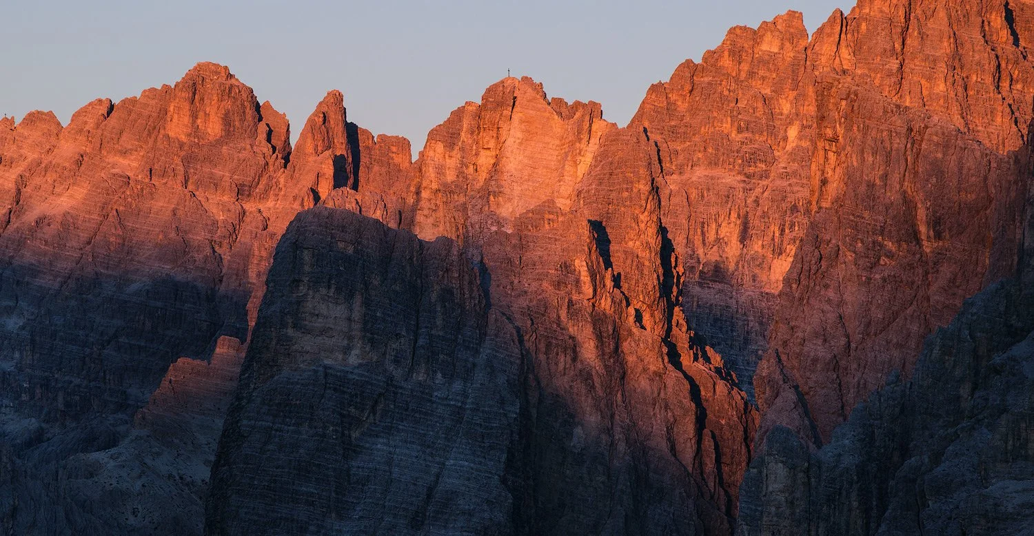 Warm evening light on rugged mountain faces seen from Passo Giau in the Italian Dolomites.