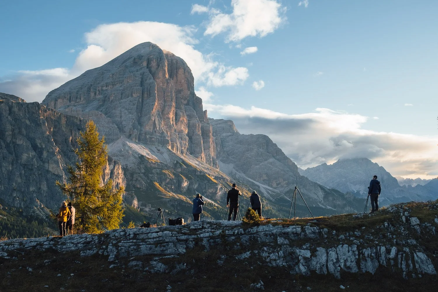 Workshop participants exploring rocky ground beneath the mountains at Passo Falzarego.