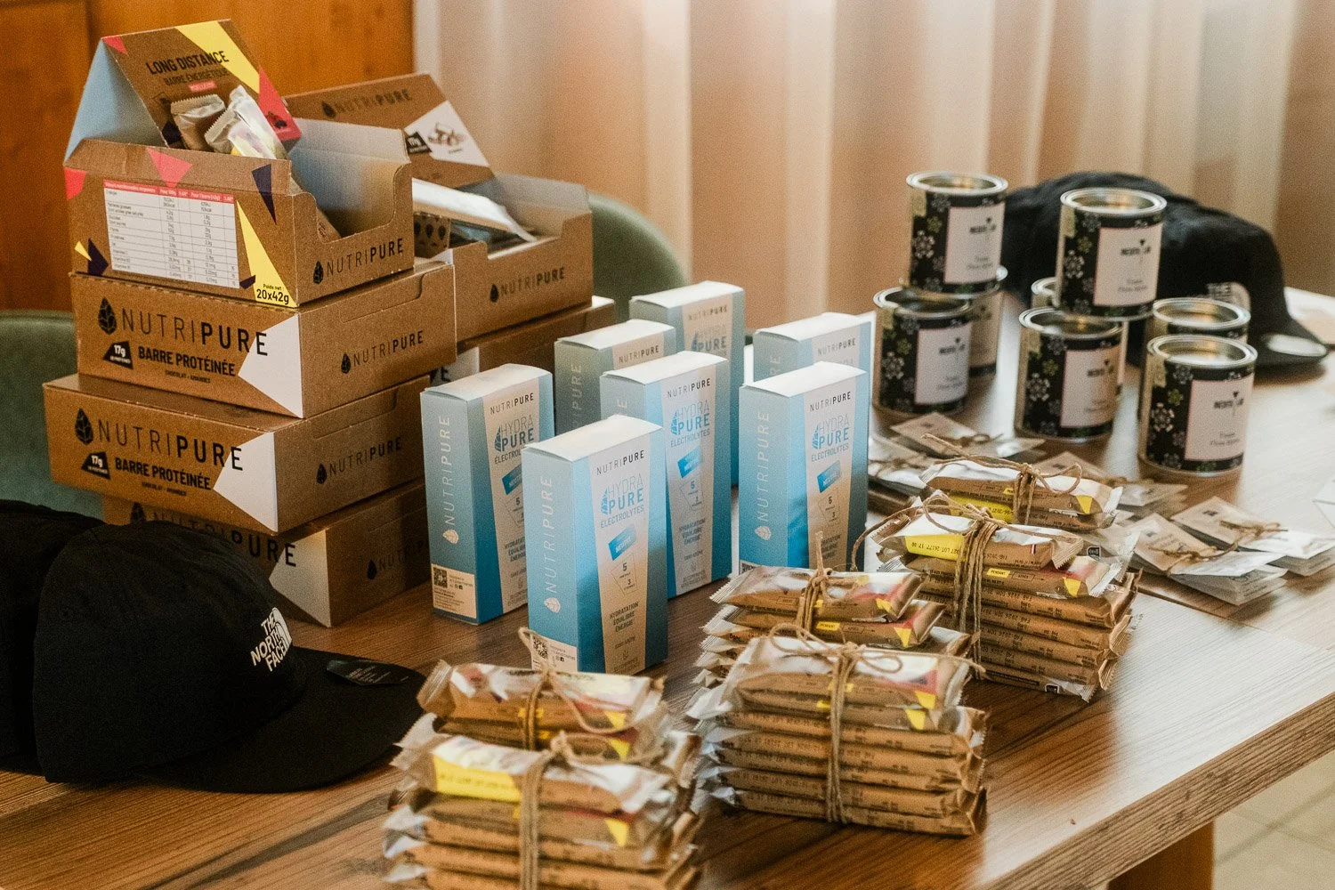 Workshop support products arranged on a table, including Nutripure supplies and The North Face beanies.