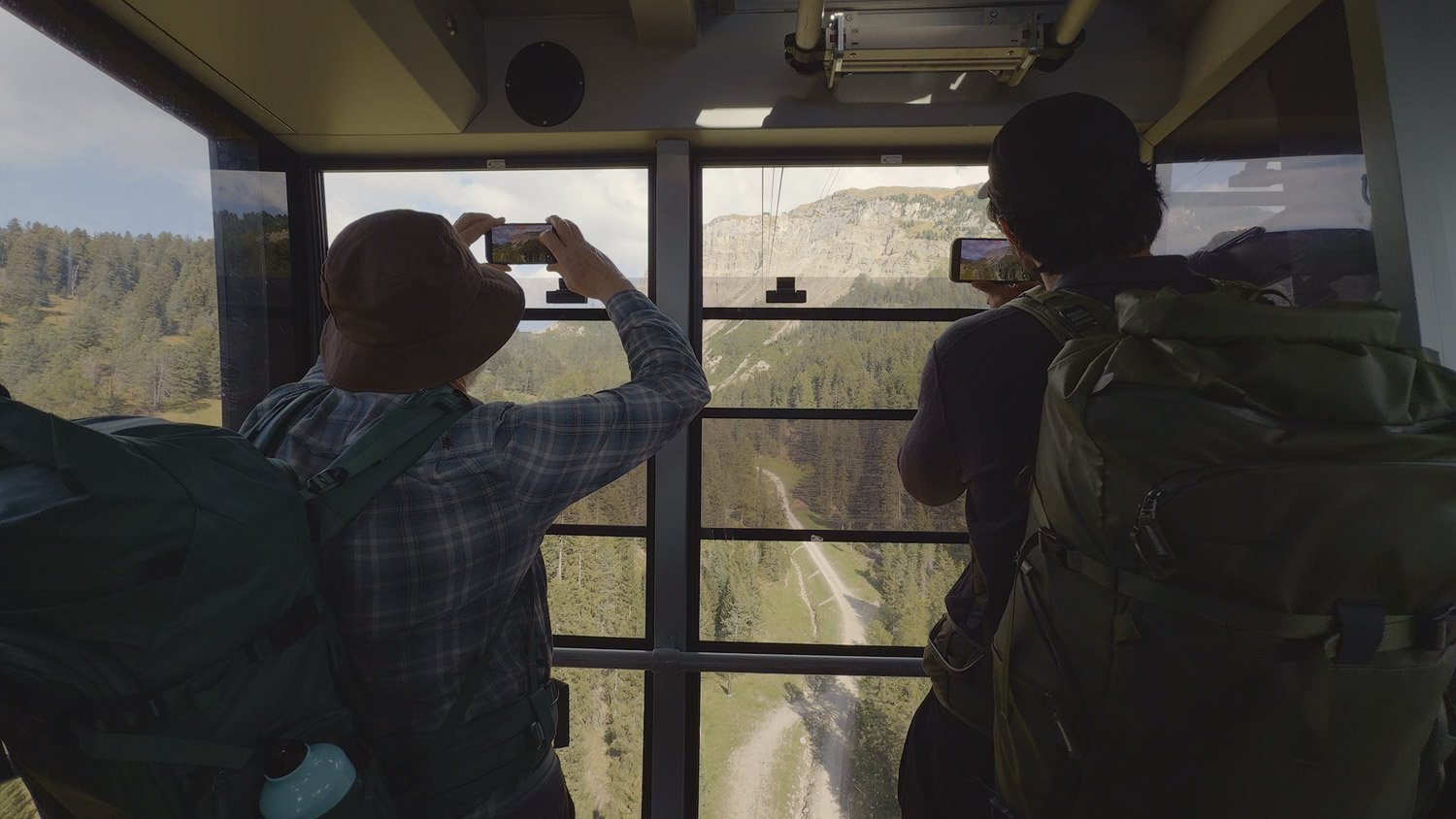 Workshop participants photographing the mountain scenery through the windows of the cable car on the way to Seceda.