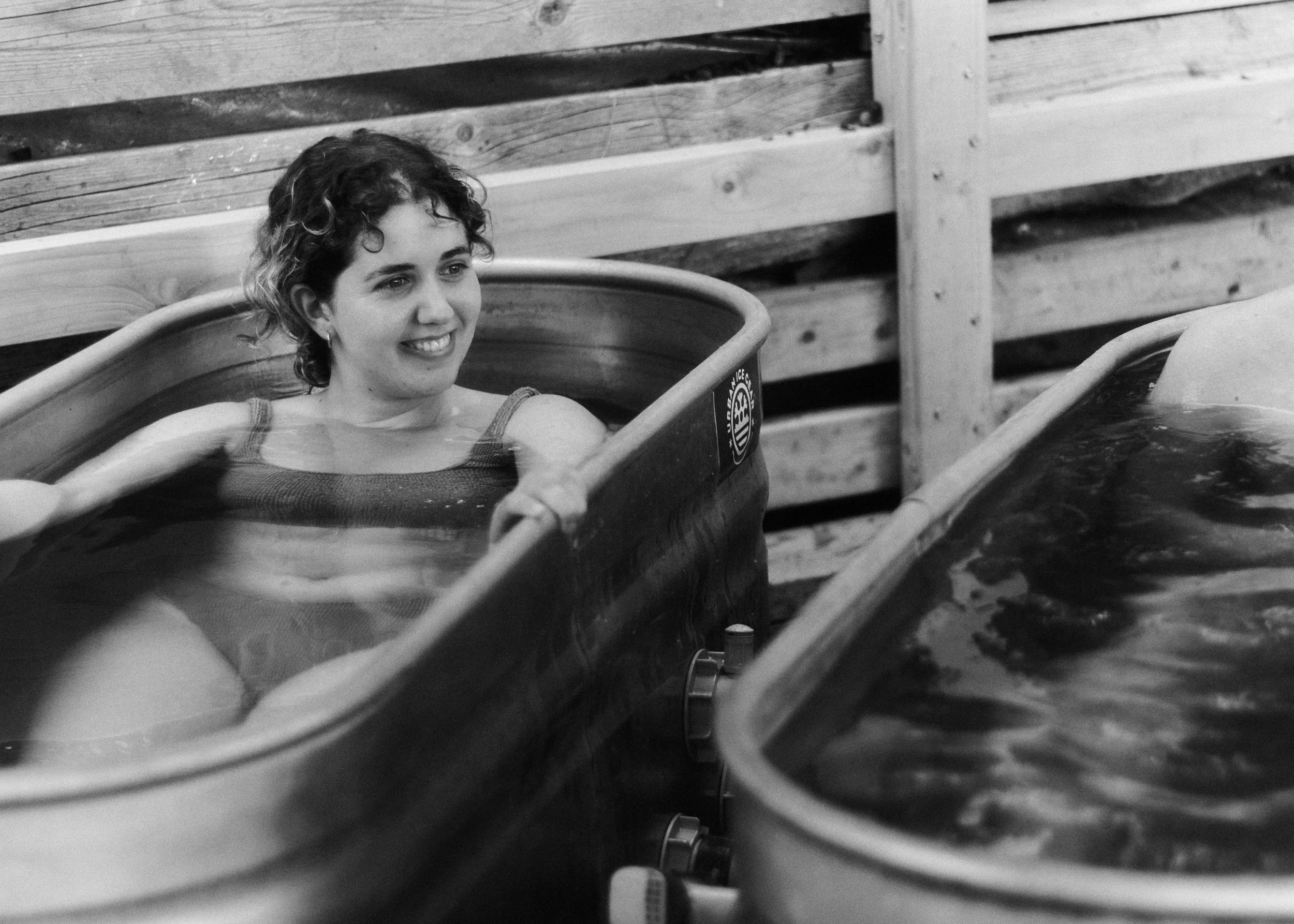 bather smiling in the cold plunge at Peckham Community Sauna Baths